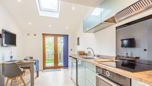 A modern kitchen with a built-in oven, a dishwasher, and a large window above the sink.