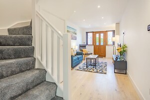 A staircase leading to a living area with a sofa, a coffee table, and a lamp.