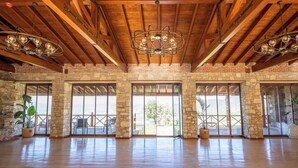 A spacious room with a high wooden ceiling, large windows, and a chandelier. - Ephesus Retreat (Selçuk)