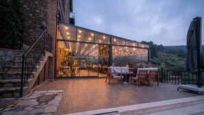 A modern building with a glass facade, outdoor seating area, and stone steps. - Ephesus Retreat (Selçuk)