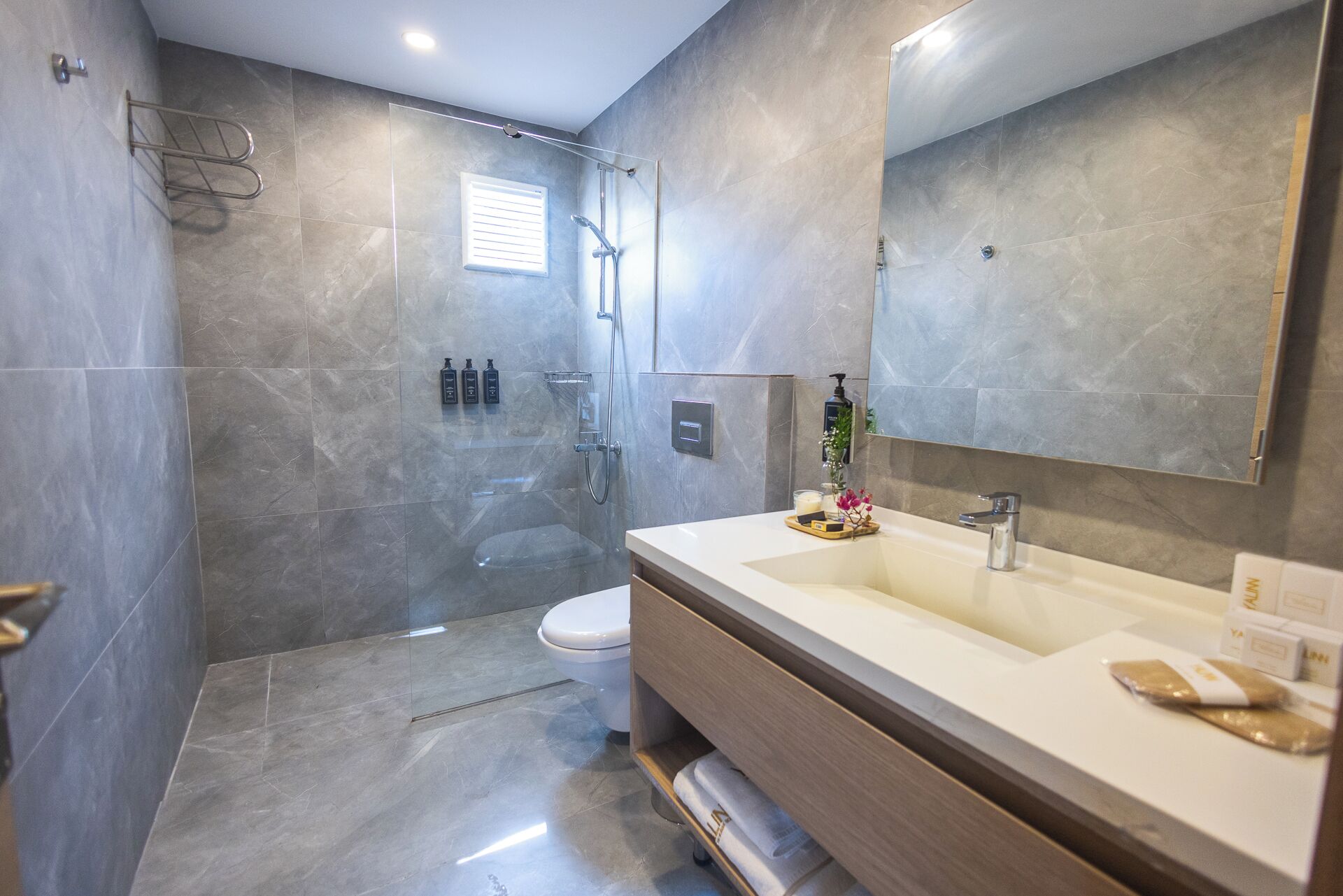 Une salle de bain moderne équipée d’une douche, de toilettes et d’un meuble-lavabo.