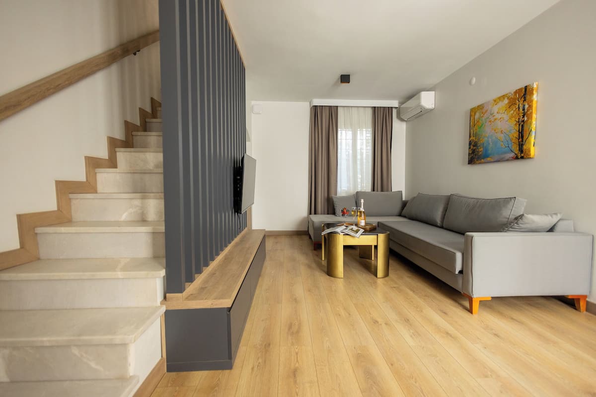 A modern living room with a staircase, a sofa, and a coffee table.