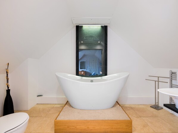 Un baño moderno con una bañera independiente, un inodoro y un lavabo.