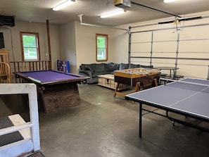 Une salle de loisirs équipée d’une table de billard, d’un baby-foot et d’une table de ping-pong.