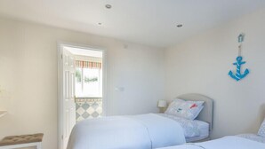 Un dormitorio con dos camas, un banco y vistas al exterior.