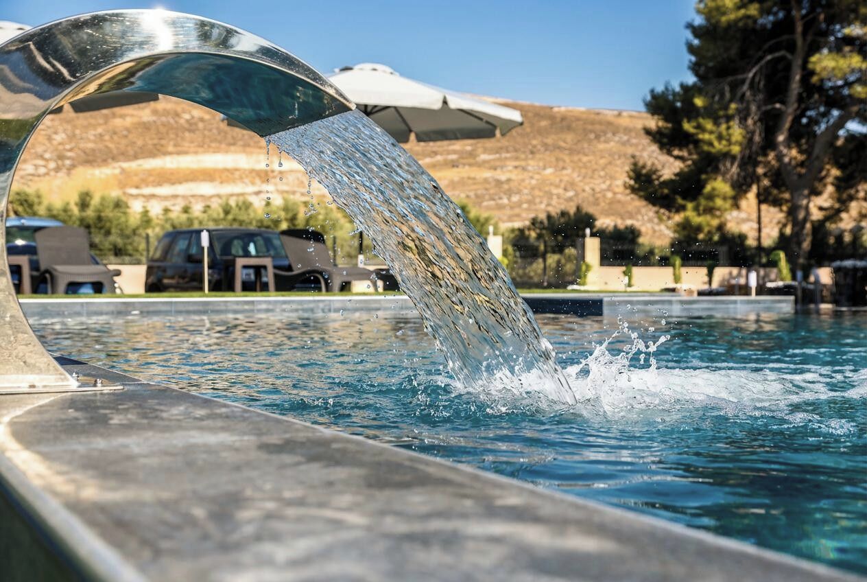 En säsongsöppen utomhuspool, parasoller och solstolar