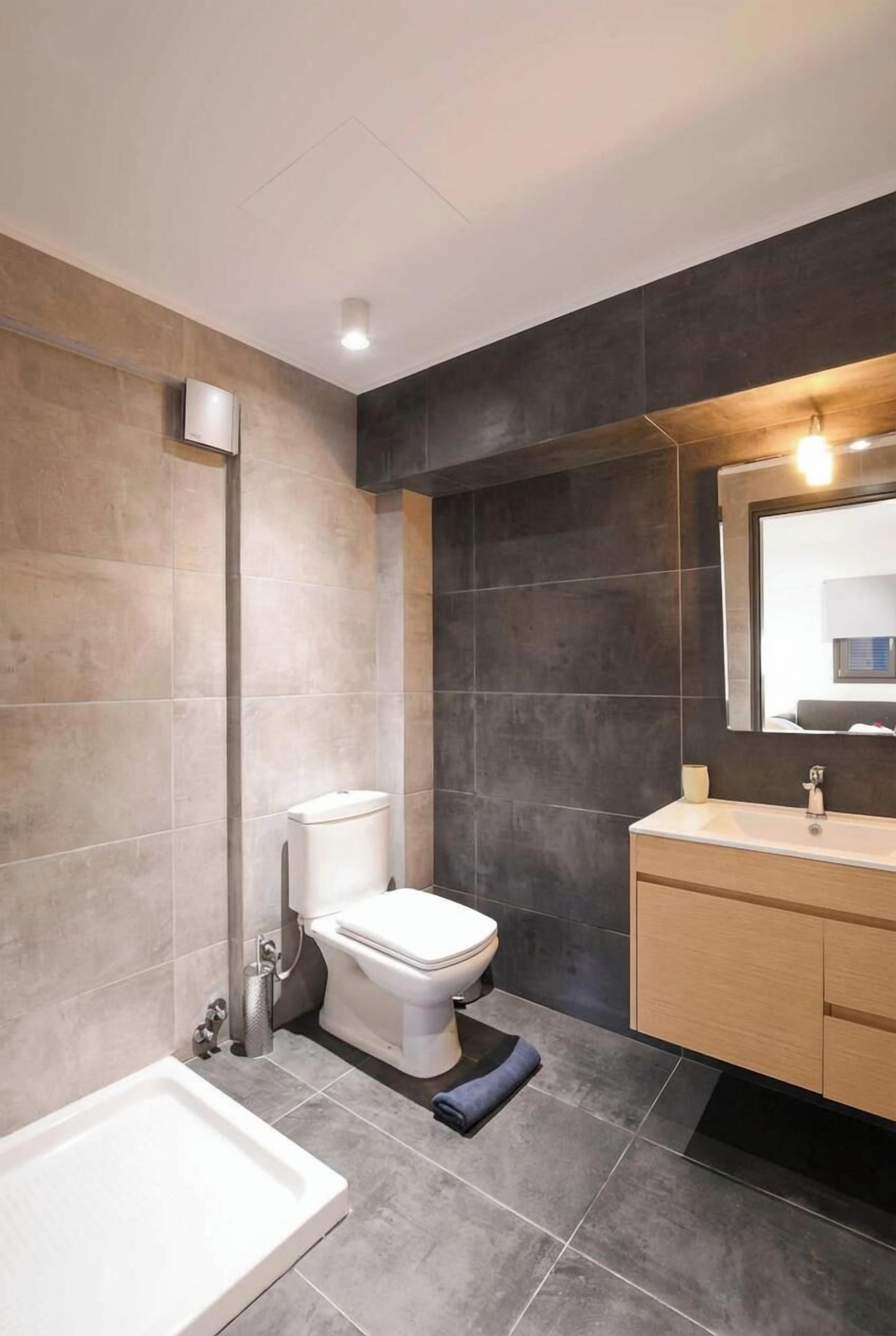 A modern bathroom with a toilet, sink, and bathtub.