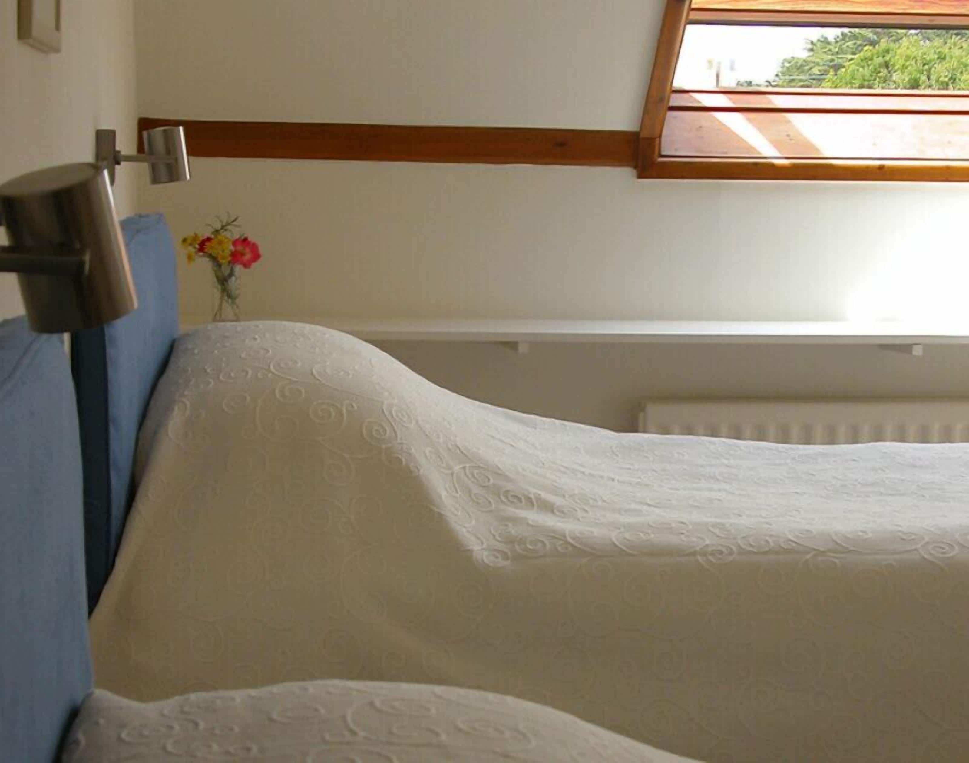 A bedroom with a bunk bed, a window with a view, and a radiator.