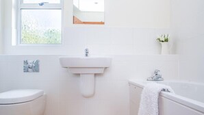 A bathroom with a toilet, sink, and bathtub. - Rosevallen (Wadebridge)