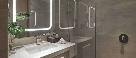 A modern bathroom with a large mirror, a shower, and a sink.