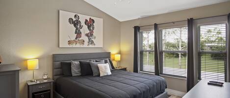 A bedroom with a bed, bedside tables, a ceiling fan, and a window with blinds.