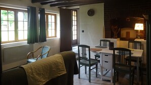 Un comedor acogedor con una mesa y sillas, una chimenea y una ventana con cortinas.