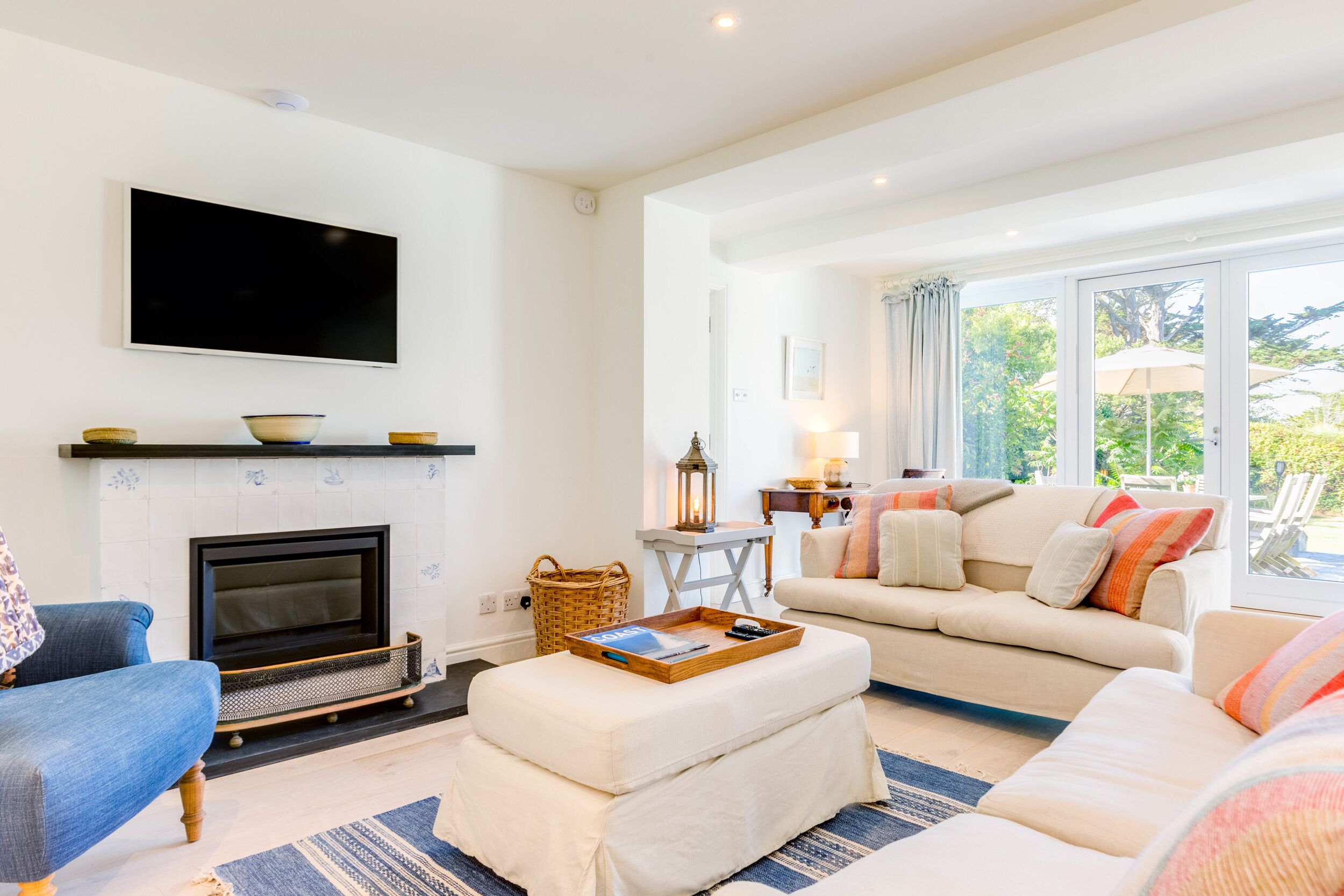 Ein Wohnzimmer mit Kamin, Sofa und Wandfernseher.