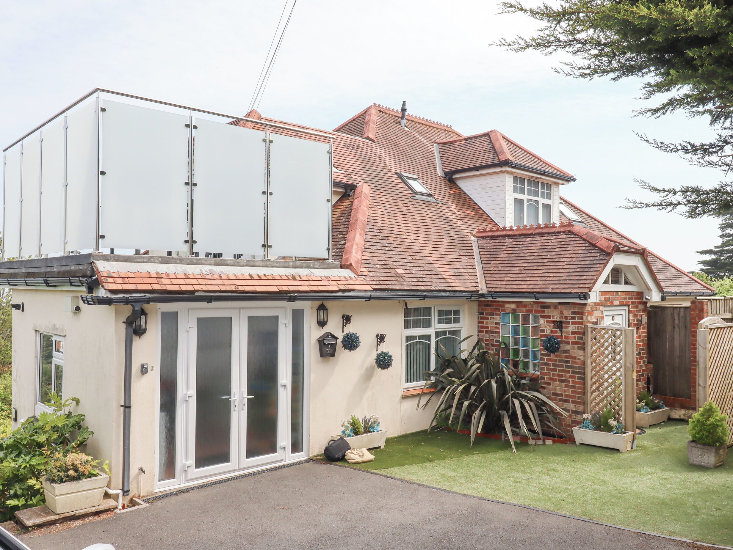 A two-story house with a large attached garage, a brick exterior, and a well-maintained lawn.