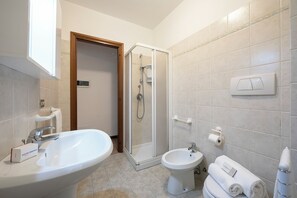 Een douche, een haardroger, een bidet, handdoeken