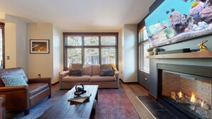 A living room with a fireplace, a sofa set, and a large aquarium. - Luxurious Home on Sierra Star Golf Course. Balcony & Gas Grill, Washer/Dryer (Mammoth Lakes)