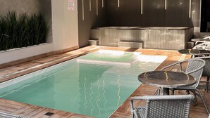 A modern indoor pool area with a seating area and a reception desk. - Pousada Duas Ilhas (Penha)