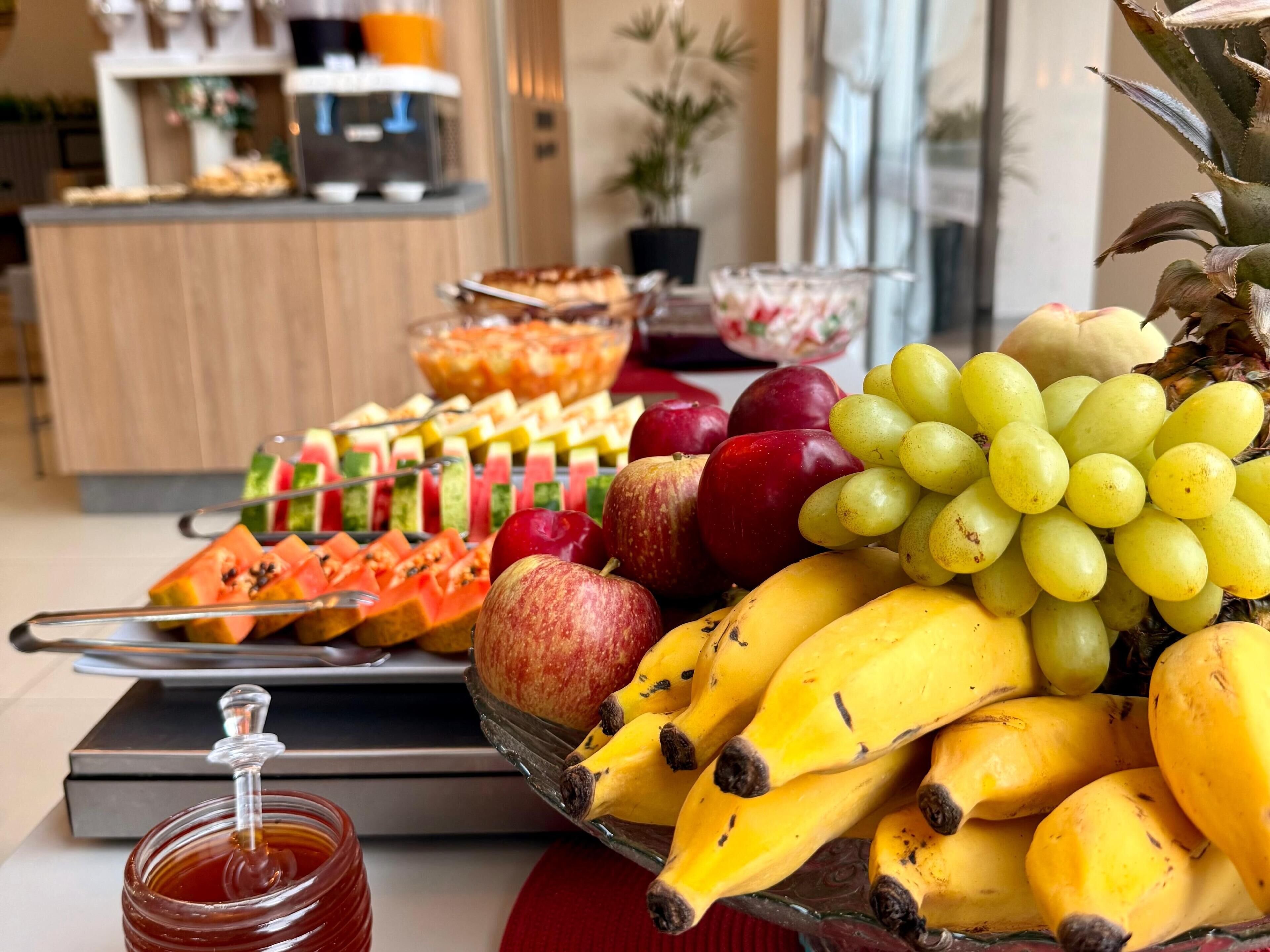 A fruit platter with bananas, apples, grapes, and watermelon slices.