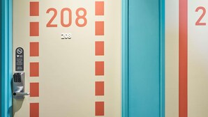 A hotel room door with the number 208, a keypad lock, and a sign indicating a 6-digit code and push button. - Ibis Budget Nancy Laxou (Laxou)
