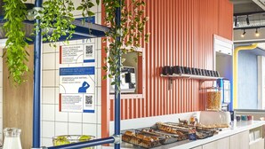 A breakfast bar with a variety of pastries, a coffee machine, and a bottle of syrup. - Ibis Budget Nancy Laxou (Laxou)