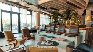 Un espace détente moderne avec des fauteuils en cuir, une table basse et une grande plante.