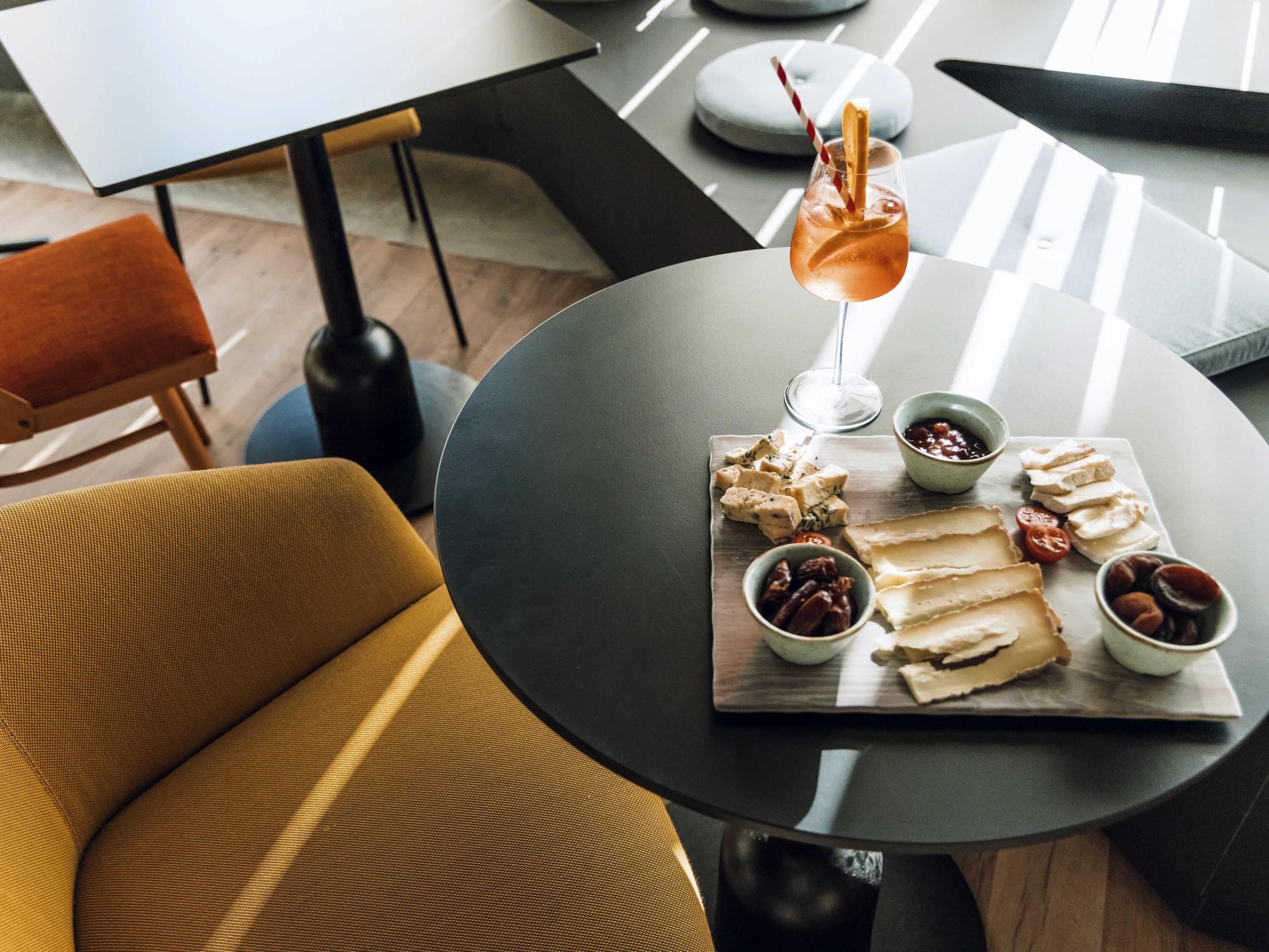 A modern dining area with a round table, a chair, and a glass of drink.