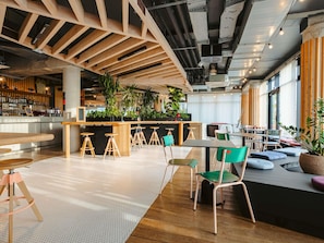 A modern interior with a bar area, seating, and large windows. - ibis Styles La Rochelle Centre Gare (La Rochelle)
