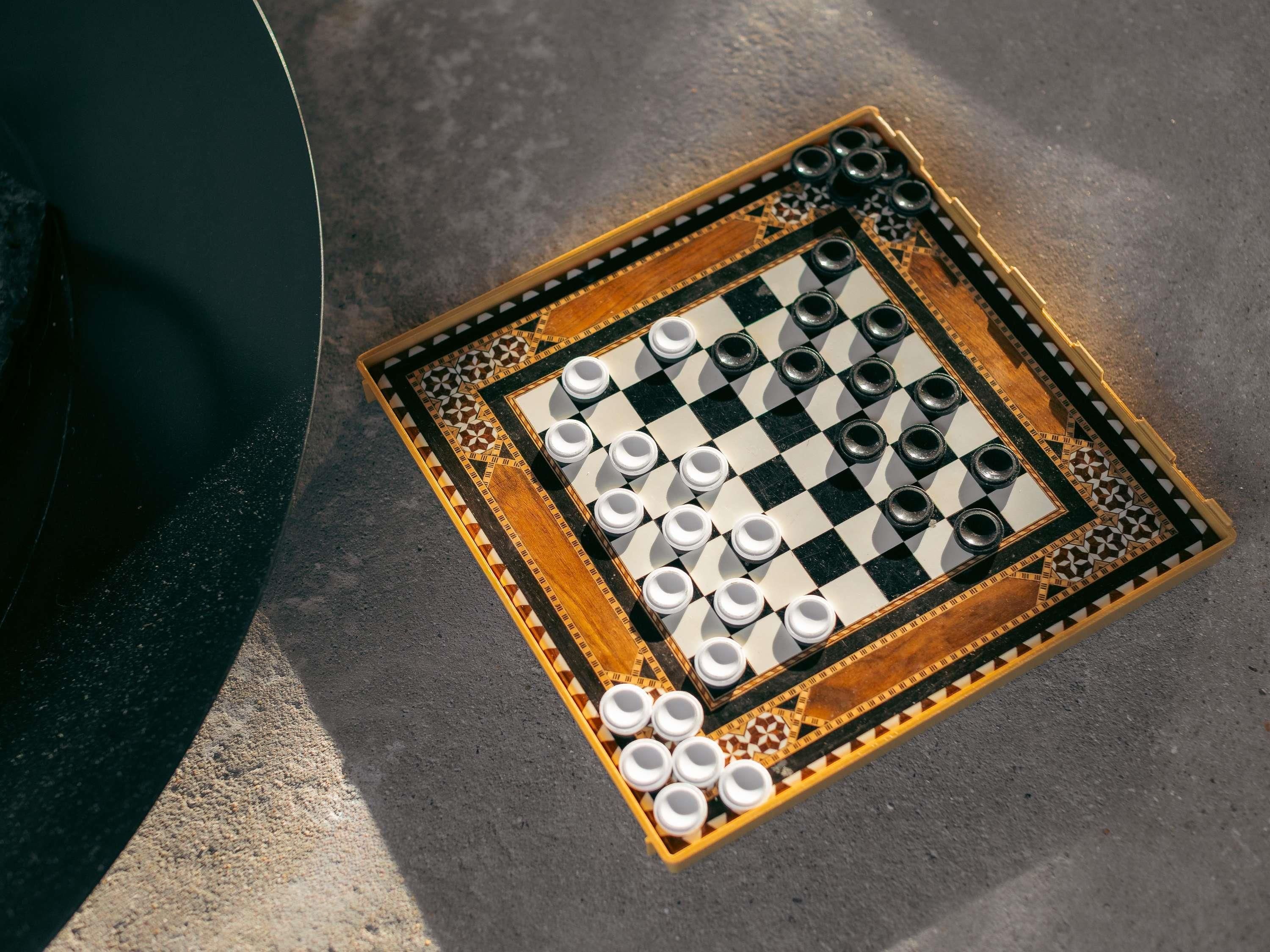 A checkered board game with pieces and a patterned border.