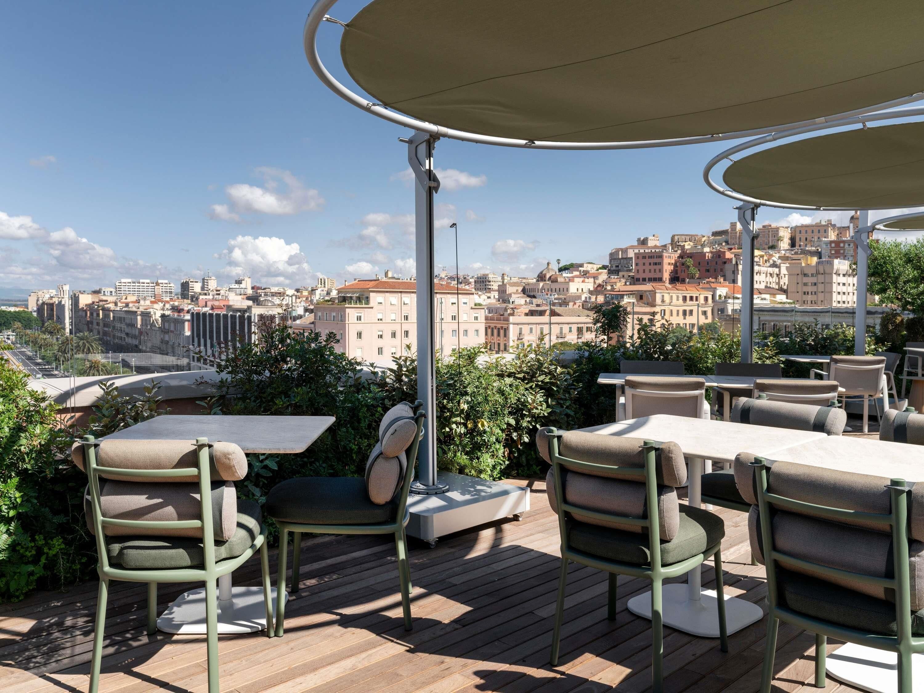 Une terrasse extérieure avec des tables et des chaises, offrant une vue sur le paysage urbain.