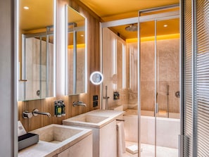 Une salle de bain moderne avec deux lavabos, un miroir, une douche et un espace de douche séparé par des parois en verre.