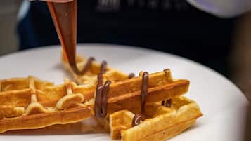 Ein Waffel wird mit Schokoladensauce übergossen.