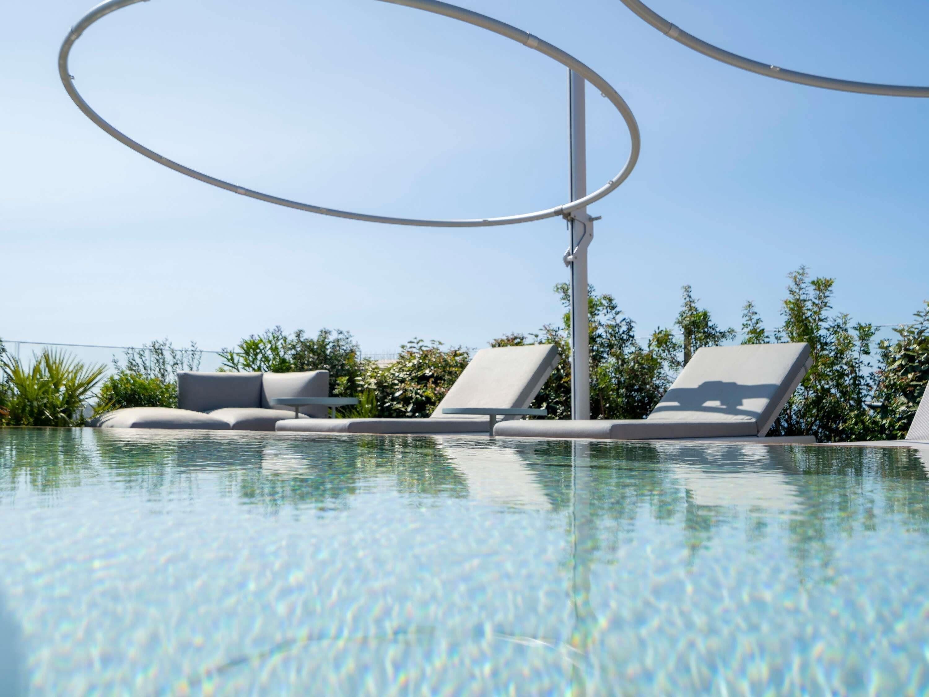 Piscine extérieure, parasols de plage, chaises longues