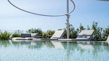 Piscine extérieure, parasols de plage, chaises longues