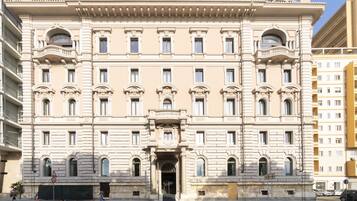 Un grand bâtiment historique à la façade symétrique, doté de nombreuses fenêtres et d’une entrée centrale.