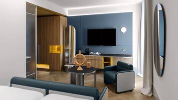 Une chambre d’hôtel moderne équipée d’un lit, d’un coin salon avec une table, d’une télévision et d’un minibar.