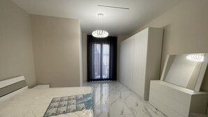Une chambre à coucher moderne avec un grand lit, un miroir et un lustre.