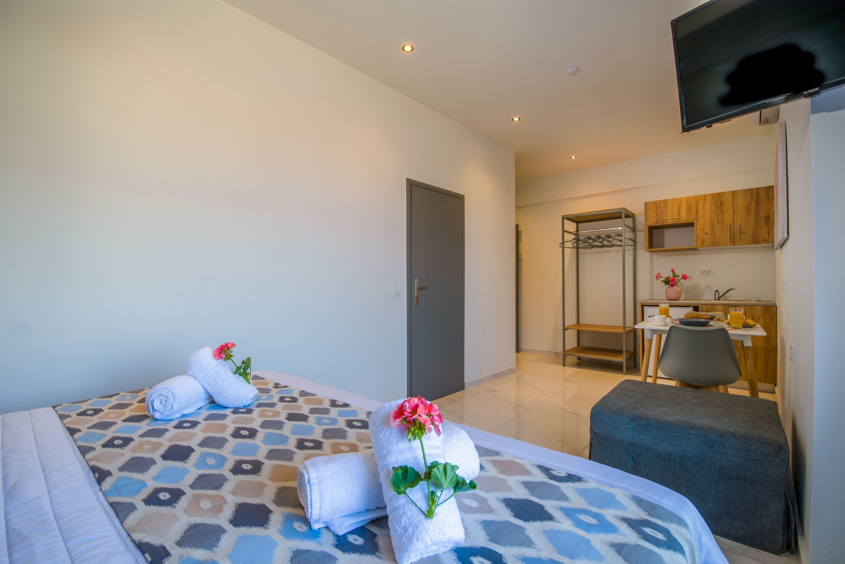 Una habitación de hotel con cama, escritorio y televisión.