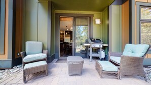 An outdoor patio area with wicker furniture, a barbecue grill, and a view of the interior through a glass door. - Solstice #14 2 Bedroom Condo by RedAwning (Mammoth Lakes)