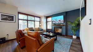 A living room with a leather sofa, a coffee table, a fireplace, and a television. - Solstice #14 2 Bedroom Condo by RedAwning (Mammoth Lakes)