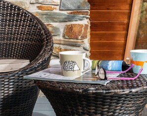 Wicker chairs, a stone wall, and a wooden door. - Alpine Lodge (Wadebridge)
