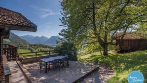 A patio with a table and chairs overlooking a mountainous landscape.