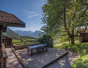 A patio with a table and chairs overlooking a mountainous landscape. - Bergerie – Loft Apartment with Panoramic Lake & Mountain Views (Talloires-Montmin)