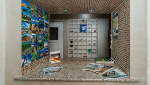 Un rincón de lectura pequeño y cerrado, con un muro de azulejos, una puerta y una estantería con revistas.