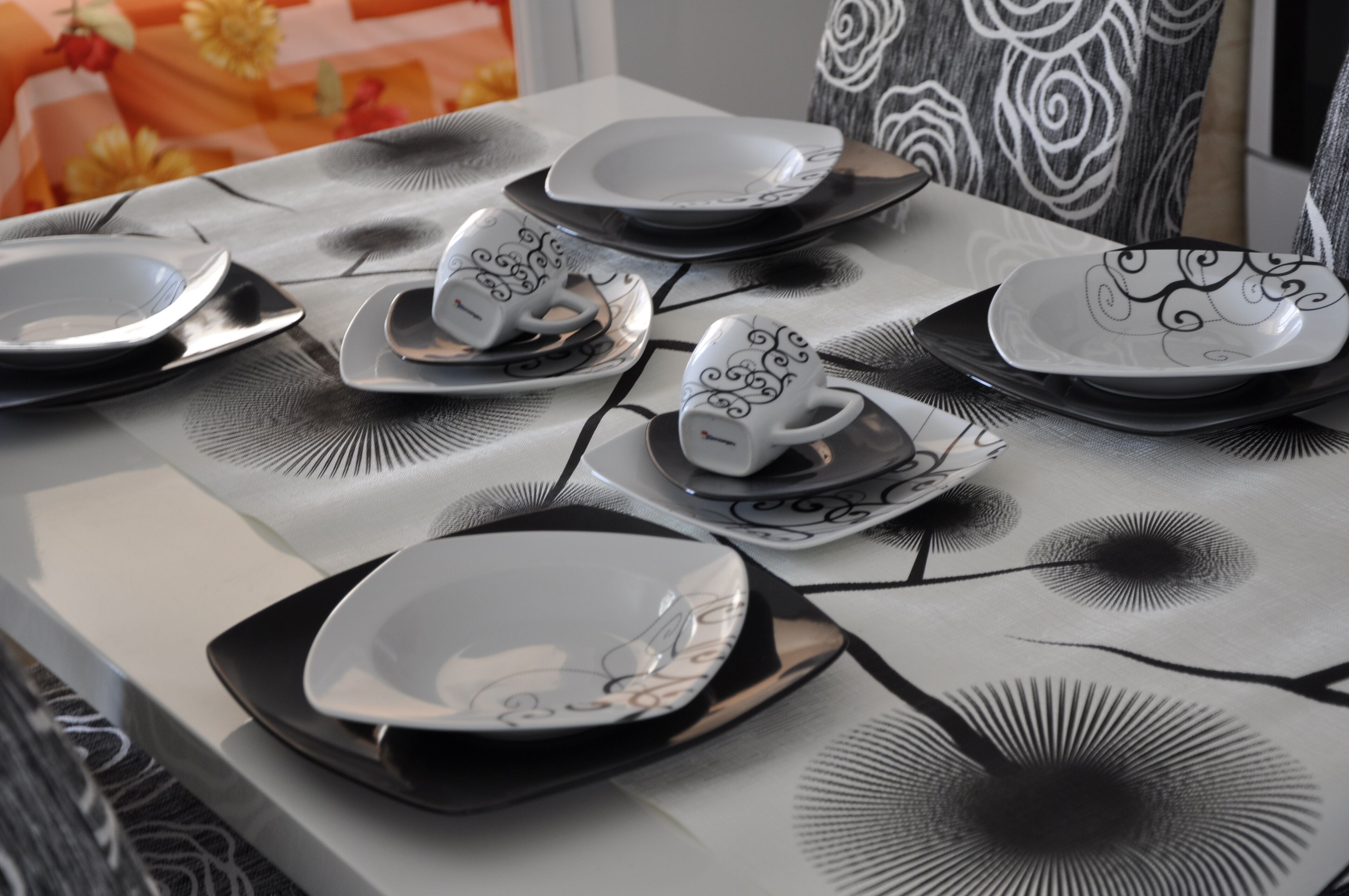 Una mesa dispuesta con varios platos y tazas, algunas con diseños intrincados.