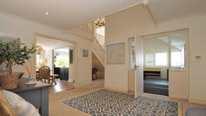 Un vaste espace de vie comprenant un escalier, une table à manger et un grand tapis.