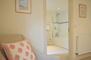 A room with a bed, a shower area, and a radiator.