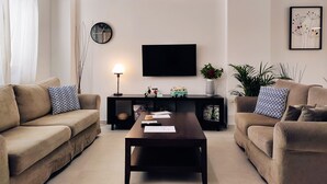 A modern living room with two sofas, a coffee table, a TV, and decorative items.