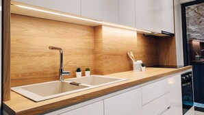A modern kitchen with two sinks, wooden countertops, and a built-in oven.