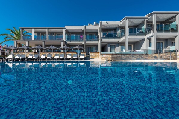 Relax by the pool surrounded by lounge chairs and umbrellas.