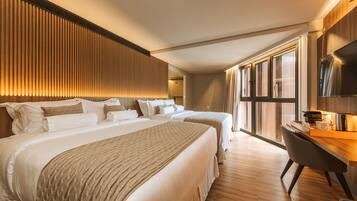 A hotel room with a large bed, a desk, and a TV.